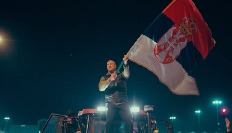 Učesnik građanskog skupa sa zastavom Srbije